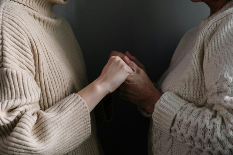 A close-up of two people holding hands, emphasizing warmth and connection.