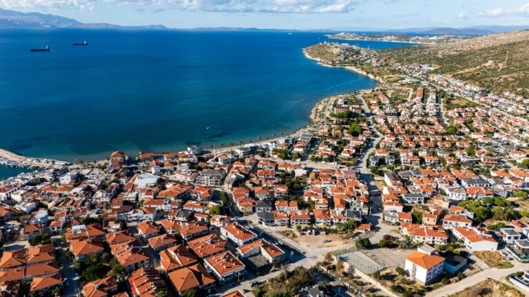 Stunning aerial view of a quaint coastal town with red rooftops along the Aegean Sea.