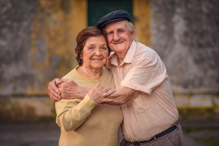 Heartwarming image of an elderly couple embracing outdoors, embodying love and companionship.