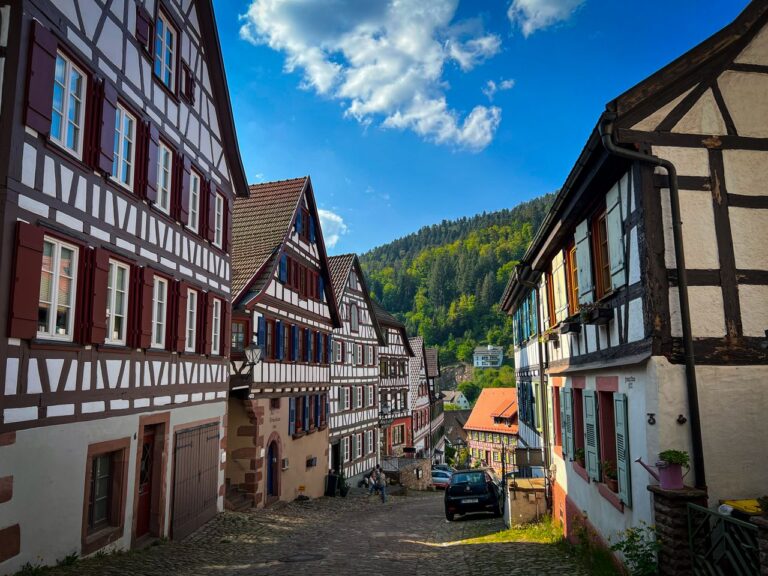Charming street with Alemannic timber-framed houses in a scenic hillside town.