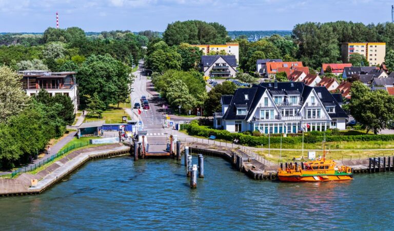 Scenic aerial view of a harbor in Rostock, Germany with colorful buildings and lush greenery.